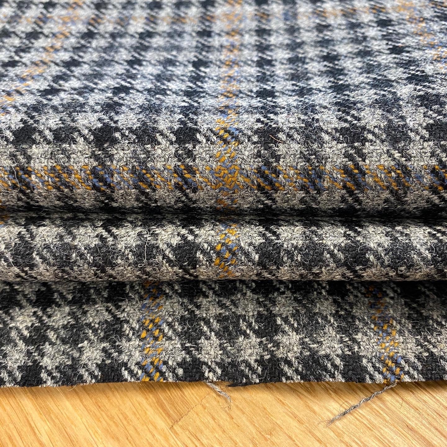 Black, grey and yellow plaid tweed fabric. 